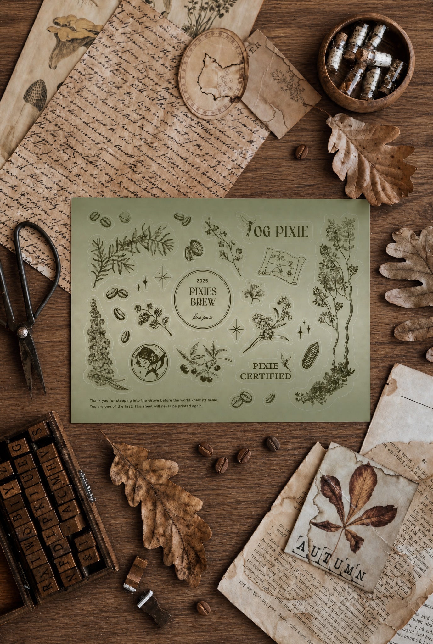 A styled flat-lay of a vintage-style collectible card or print from 'The Pixie' reading '106 Pixie' and 'Pixie Certified,' placed on a wooden surface surrounded by autumn-themed props including dried leaves, old letters, stamps, scissors, and a small bowl of capsules.
